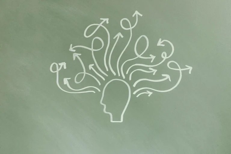 Chalk drawing of a head with many arrows pointing outward, symbolising thoughts.